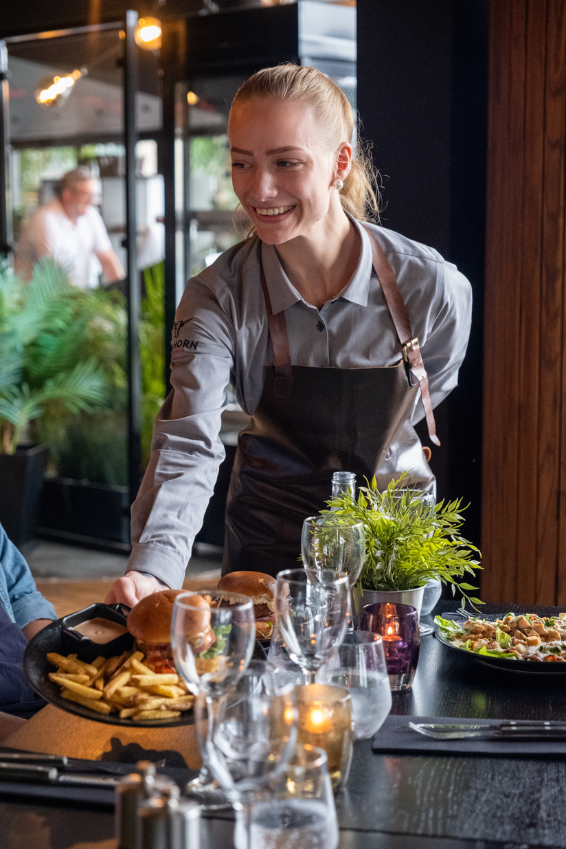 Smilende servitør som serverer mat Big Horn restaurant